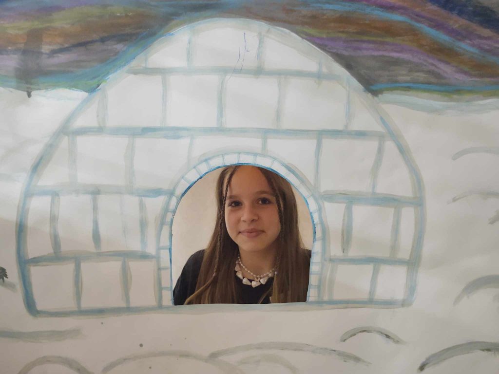 Zdjęcie dziewczynki z głową w otworze igloo
