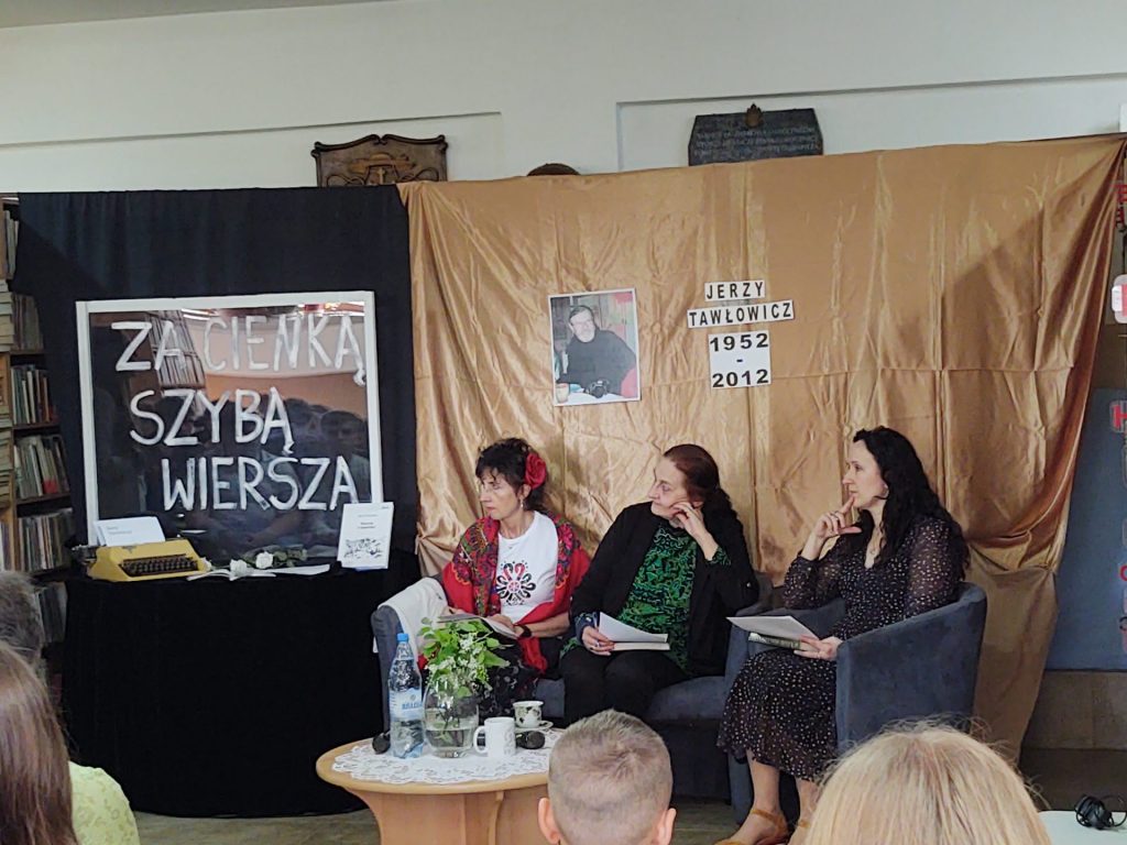 Siedzące jury. W tle dekoracja na czarno-złotych tkaninach